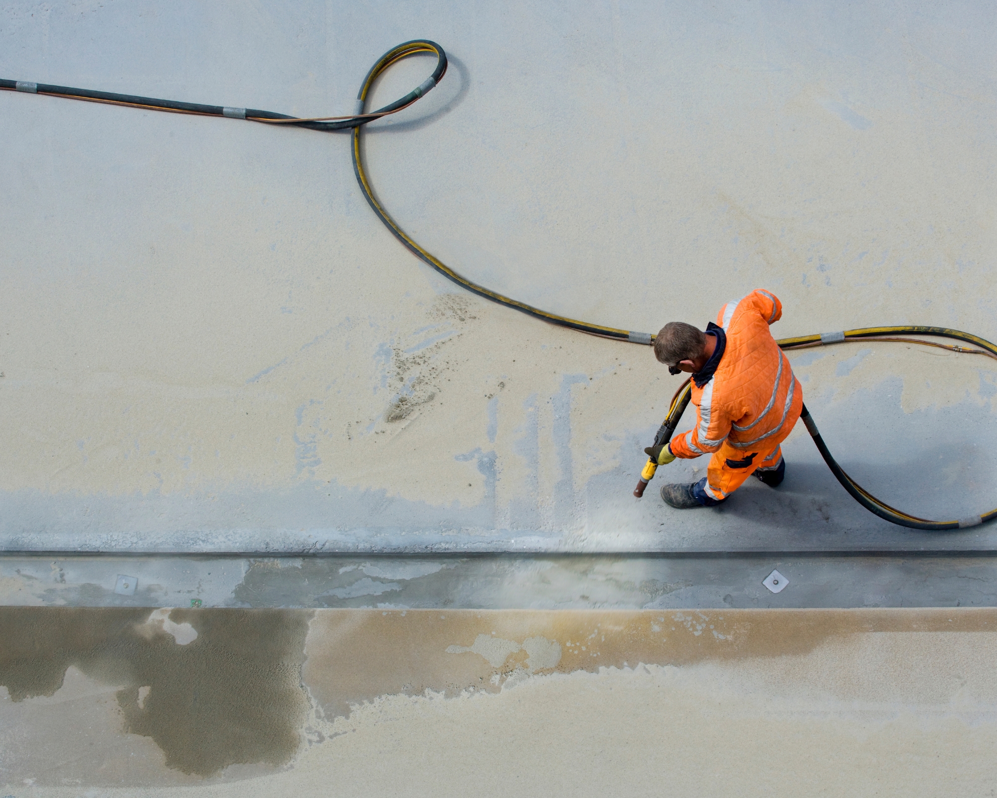 Homme avec tenue de chantier pendant travaux d'hydrogommage